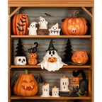 Bethany Lowe Designs - Frightened Fergus is a ghost with a sweet expression and glasses. He is wearing a witch hat with a spider dropping from it and holding a jack o lantern in his lap. He sits on a shelf amongst other Bethany Lowe vintage inspired Halloween characters. 